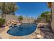 Luxury swimming pool area with rock features, desert plants, privacy walls, and lounge chairs at 3824 E Parkside Ln, Phoenix, AZ 85050
