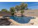 Backyard swimming pool featuring custom rock details, desert landscaping, and clear blue water at 3824 E Parkside Ln, Phoenix, AZ 85050