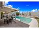 Backyard pool and patio with string lights, ceiling fan, desert landscaping, and blue skies at 4136 W Hearn Rd, Phoenix, AZ 85053