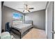 A carpeted bedroom with gray walls, ceiling fan, window, and a queen bed frame at 4136 W Hearn Rd, Phoenix, AZ 85053