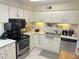 Well-lit kitchen with stainless steel appliances, white cabinets, and ample counter space at 4201 E Camelback Rd # 51, Phoenix, AZ 85018