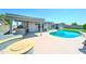 A refreshing pool and covered patio area with an outdoor kitchen, built-in seating, and a fire pit at 4201 W Hatcher Rd, Phoenix, AZ 85051