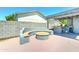Outdoor living space with built-in seating and firepit next to a covered patio and a full outdoor kitchen at 4201 W Hatcher Rd, Phoenix, AZ 85051