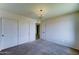 This bedroom features carpet, a light fixture, a closet, and an adjoining doorway at 4201 W Hatcher Rd, Phoenix, AZ 85051
