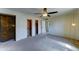 Bright bedroom featuring carpet, a ceiling fan, light walls, and closet space at 4201 W Hatcher Rd, Phoenix, AZ 85051