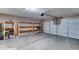 Spacious two car garage with automatic door opener, concrete floor, and open wood shelving for storage at 4201 W Hatcher Rd, Phoenix, AZ 85051