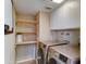 Well-lit laundry room with stainless steel washer and dryer, overhead cabinets, and functional, open wood shelving at 4201 W Hatcher Rd, Phoenix, AZ 85051
