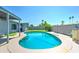 Lush backyard oasis featuring a sparkling blue pool with a covered patio and an outdoor kitchen at 4201 W Hatcher Rd, Phoenix, AZ 85051