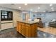 Kitchen island with wood cabinets offering seating, opening to the brick-accented living room with a fireplace at 4304 W Calle Poco --, Laveen, AZ 85339