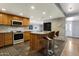 Modern kitchen featuring an island with barstool seating, wood cabinetry, and stainless steel appliances at 4304 W Calle Poco --, Laveen, AZ 85339