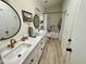 Well-lit bathroom featuring a white vanity, dual mirrors, and a shower-tub combo at 4925 W Bluefield Ave, Glendale, AZ 85308