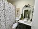Cozy bathroom featuring a stylish vanity with gold fixtures and a shower with patterned curtains at 4925 W Bluefield Ave, Glendale, AZ 85308