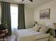 Relaxing bedroom with neutral tones, a ceiling fan, and window with green curtains at 4925 W Bluefield Ave, Glendale, AZ 85308