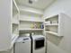 Functional laundry room with a side-by-side washer and dryer and built-in shelves for storage at 4925 W Bluefield Ave, Glendale, AZ 85308