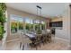 Bright dining area with large windows overlooking a pool, featuring a rustic table and modern chandelier at 5085 S Ponderosa Dr, Gilbert, AZ 85298