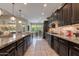 Spacious kitchen with dark wood cabinetry, granite countertops, and a central island with pendant lighting at 5085 S Ponderosa Dr, Gilbert, AZ 85298