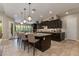 Modern kitchen with a large island, pendant lighting, dark cabinetry, and seating for four at the bar at 5085 S Ponderosa Dr, Gilbert, AZ 85298