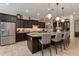 Well-equipped kitchen with stainless steel appliances, dark wood cabinets, and a granite-topped island with bar seating at 5085 S Ponderosa Dr, Gilbert, AZ 85298