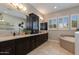 Luxurious main bathroom with dual vanities, stylish cabinetry, and a soaking tub with natural light coming from the windows at 5085 S Ponderosa Dr, Gilbert, AZ 85298