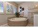 Relaxing soaking tub with a decorative tile surround, offering a peaceful retreat in the spa-like bathroom at 5085 S Ponderosa Dr, Gilbert, AZ 85298