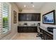 Home office nook featuring custom cabinets, granite countertop, and natural light from the window with shutters at 5085 S Ponderosa Dr, Gilbert, AZ 85298
