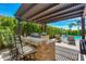 Outdoor kitchen features a stone bar, BBQ grill, and a pergola, providing shade and style at 5085 S Ponderosa Dr, Gilbert, AZ 85298