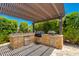 Outdoor kitchen and BBQ area with stainless steel appliances and stone accents beneath a shaded pergola at 5085 S Ponderosa Dr, Gilbert, AZ 85298