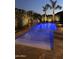 Beautifully lit pool with palm trees and lush landscaping, perfect for evening relaxation and entertainment at 5085 S Ponderosa Dr, Gilbert, AZ 85298