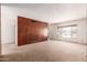 Spacious living room with a large window, carpet flooring, and wood paneling accent wall at 548 W Linda Ln, Chandler, AZ 85225