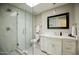 Bright bathroom featuring a shower with glass door, a vanity with modern finishes, and updated lighting at 5541 E Cheery Lynn Rd, Phoenix, AZ 85018