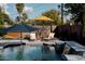 Inviting pool area featuring lounge chairs, umbrellas, waterfall feature, and lush landscaping in the background at 5541 E Cheery Lynn Rd, Phoenix, AZ 85018
