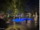 Sparkling pool surrounded by trees adorned with festive lights in a serene backyard setting at 6139 E Voltaire Ave, Scottsdale, AZ 85254