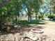 A beautiful backyard featuring mature trees, a fire pit, lush green grass, and charming landscaping at 6139 E Voltaire Ave, Scottsdale, AZ 85254