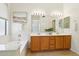 Bathroom featuring a double vanity, bathtub, and soft natural light at 6781 W Lone Cactus Dr, Glendale, AZ 85308