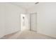 A carpeted bedroom with a closet and adjacent bathroom doorway offers a blank canvas at 6781 W Lone Cactus Dr, Glendale, AZ 85308