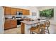 Bright kitchen featuring warm wood cabinetry, modern appliances, and an island with barstool seating at 6781 W Lone Cactus Dr, Glendale, AZ 85308