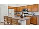 Functional kitchen with wood cabinets, modern appliances, and an island perfect for meal preparation at 6781 W Lone Cactus Dr, Glendale, AZ 85308