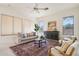 Cozy living room with neutral tones, a ceiling fan, large windows, and stylish furnishings at 6781 W Lone Cactus Dr, Glendale, AZ 85308