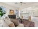 Open concept living space with kitchen featuring a breakfast bar and a cozy living room area at 6781 W Lone Cactus Dr, Glendale, AZ 85308