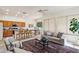 Open living space blending a kitchen with breakfast bar and a living area with a ceiling fan at 6781 W Lone Cactus Dr, Glendale, AZ 85308