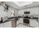 Well-lit kitchen with stainless steel appliances, white cabinets, and black countertops at 7575 E Indian Bend Rd # 1142, Scottsdale, AZ 85250