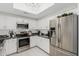 Updated kitchen with modern appliances, white cabinetry, and stylish backsplash at 7575 E Indian Bend Rd # 1142, Scottsdale, AZ 85250
