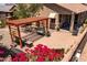 Well-appointed outdoor area with pergola, brick patio, seating, lush landscaping, and a barbecue at 7648 S Thimble Peak --, Gold Canyon, AZ 85118