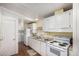 Galley kitchen with white cabinets and appliances, including a washer and dryer behind a door at 8103 E Southern Ave # 75, Mesa, AZ 85209