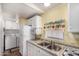 Kitchen sink with white appliances, including a microwave, and an eat-in countertop island nearby at 8103 E Southern Ave # 75, Mesa, AZ 85209