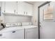 Functional laundry area with washer, dryer, overhead cabinets, and an exterior door for added convenience at 8103 E Southern Ave # 75, Mesa, AZ 85209