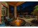 Backyard patio with seating, a fire pit and tropical landscaping near the home's swimming pool at 9678 E Voltaire Dr, Scottsdale, AZ 85260