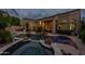 Inviting backyard pool and spa with rock features and cozy outdoor seating area with fire pit, perfect for evening relaxation at 9678 E Voltaire Dr, Scottsdale, AZ 85260