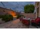 Cozy backyard patio with fire feature, outdoor seating, lush greenery, and privacy wall perfect for evening gatherings at 9678 E Voltaire Dr, Scottsdale, AZ 85260