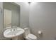 Powder room with a white pedestal sink and a large mirror, reflecting a doorway at 9678 E Voltaire Dr, Scottsdale, AZ 85260